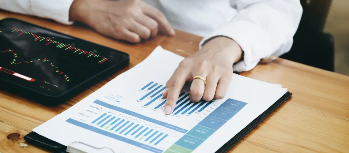 A business professional in Melbourne analysing valuation reports on a desk with charts and graphs